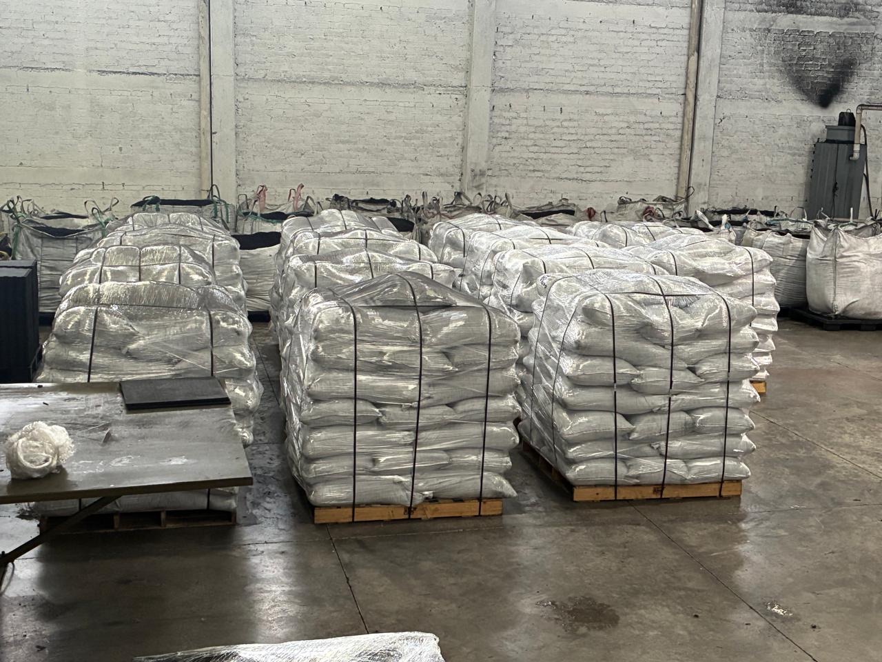 Pallets of bagged rubber material prepared inside a warehouse.